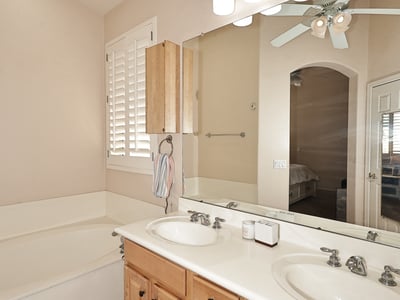 Primary bath with dual vanities, soaking tub, and abundant counter space. This Phoenix home features practical design, natural light, and comfortable finishes.