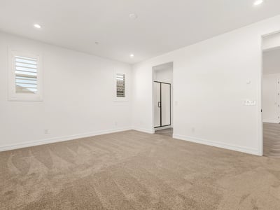 Generous primary suite with soft carpet, large windows, and peaceful ambiance. Designed for comfort and privacy.