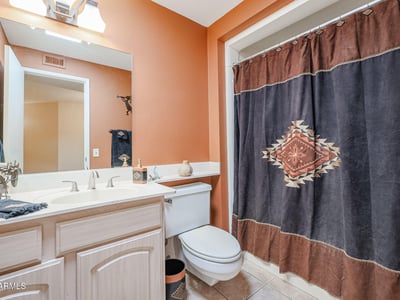 Guest bathroom featuring tub/shower combo, spacious vanity, and warm tones, offering both style and practicality.