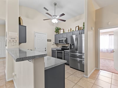 Open kitchen featuring breakfast bar, durable countertops, and included appliances ideal for casual meals and hosting.
