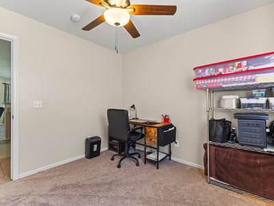Multi-use room perfect for a home office or bedroom, featuring natural light, neutral tones, and ceiling fan.