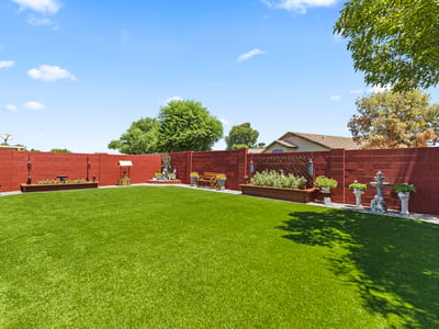 Peaceful backyard featuring mature trees, turf lawn, and privacy fencing. A relaxing outdoor environment with ample space.