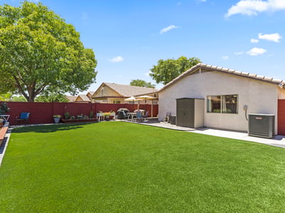 Large backyard with vibrant turf and landscaped borders, offering plenty of room for entertaining or recreation.