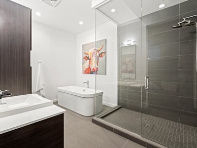 Contemporary bathroom featuring a large glass shower, freestanding tub, and designer tile, combining luxury and functionality.