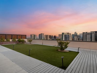 Landscaped rooftop area with open lawn and skyline views, offering a peaceful outdoor setting in this modern Phoenix property.