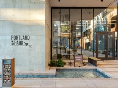Elegant lobby with glass entry doors, clean lines, and landscaped accents, offering a welcoming arrival experience in Phoenix.