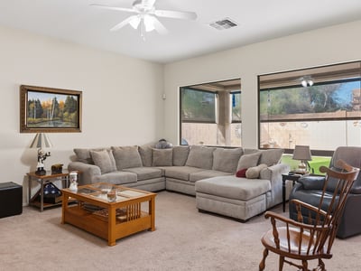 Bright living room with large windows, open layout, and comfortable design, ideal for both entertaining and relaxing in this Phoenix property.