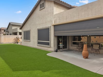 Beautiful backyard with synthetic grass, low-maintenance landscaping, and open space for outdoor enjoyment in this Phoenix home.