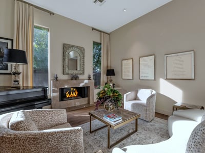 Sun-filled living room featuring designer d cor, a sleek fireplace, and large windows that enhance the open feel of this Phoenix home.