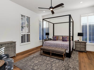 Spacious bedroom retreat with modern finishes, wood flooring, and natural light, offering comfort and privacy in this Phoenix home.