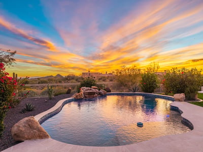 Tranquil pool setting surrounded by Scottsdale desert landscaping, highlighted by dramatic sunset colors and peaceful outdoor living spaces.