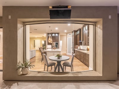 Elegant view into the modern kitchen with island seating, pendant lighting, and custom cabinetry, highlighting upscale Scottsdale interior design.
