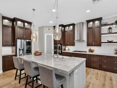 High-end kitchen with quartz island, farmhouse sink, custom cabinetry, and stainless steel appliances in this Scottsdale home.