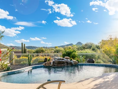 Scottsdale backyard pool overlooking scenic desert and mountain views, enhanced by mature landscaping and peaceful surroundings.