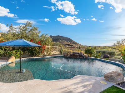 Scottsdale backyard with custom pool, rock water feature, and mountain views, creating a relaxing and private outdoor space.