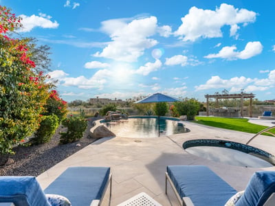 Scottsdale outdoor kitchen with pergola, built-in grill, and bar seating, creating a perfect space for entertaining guests.