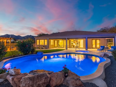 Scottsdale outdoor living at dusk with illuminated pool, spa, and patio, highlighting resort-style design and modern lighting.