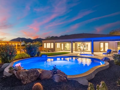 Scottsdale backyard featuring pool, spa, pergola kitchen, and desert landscaping under a dramatic sunset sky.