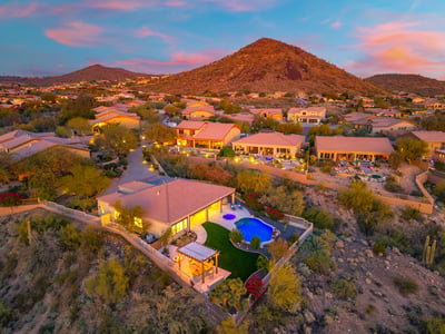 Scottsdale aerial showcasing the elevated homesite, resort-style backyard, and panoramic desert and mountain views.