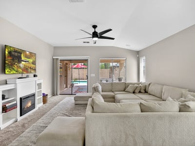 Light-filled living room with fireplace and direct access to the backyard pool area. Open design creates a welcoming space for relaxing or entertaining in this Casa Grande home.