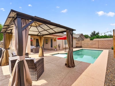 Backyard featuring a private pool and shaded pergola lounge area. Ideal for entertaining and enjoying warm Casa Grande evenings.