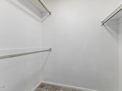 Generous walk-in closet with organized hanging space. This Sun City home includes practical storage and well-designed interiors.