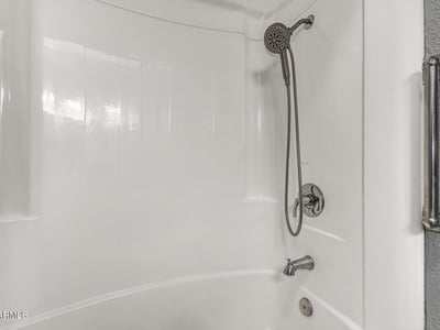 Clean bathroom featuring a tub and shower combo with modern fixtures. This Sun City home includes functional spaces and updated details.