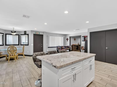Kitchen island with bar seating connects seamlessly to living and dining areas, ideal for entertaining in this Phoenix home.
