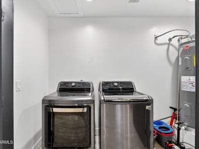 Functional laundry area with washer, dryer, and water heater, designed for efficiency and convenience in this Phoenix home.