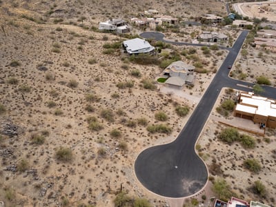 Expansive aerial view of this premium hillside lot surrounded by custom homes and breathtaking desert scenery. An ideal Phoenix location for building a luxury residence with mountain views.