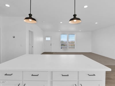 Spacious great room connected to the kitchen, creating a seamless flow throughout the home's main living areas. Recessed lighting, large windows, and an airy layout make this space ideal for family gatherings and entertaining.