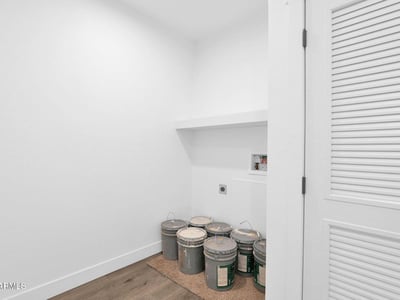 Versatile utility room offering storage shelving, laundry connections, and convenient access to household systems. This functional space enhances the home's overall practicality and organization.