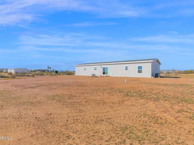 Rear view of the property highlighting the home's placement on a generous lot. The abundant outdoor space offers opportunities for landscaping, entertaining areas, and enjoying Wittmann's natural surroundings.