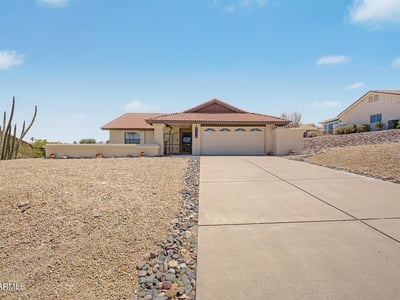 Wide-open views and desert landscaping frame this inviting Fountain Hills home. The expansive front yard and clean exterior presentation create a welcoming first impression for visitors and prospective buyers.