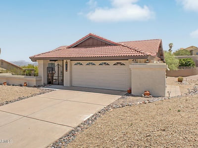 This charming home features a covered entry, spacious driveway, and thoughtfully designed exterior. The elevated setting enhances privacy while embracing the natural beauty of the surrounding desert landscape.