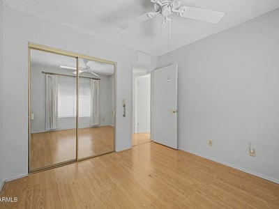 Mirrored closet doors and a generous floorplan make this secondary bedroom feel open and inviting. The adaptable space is well-suited for guests, family members, or a dedicated home office.