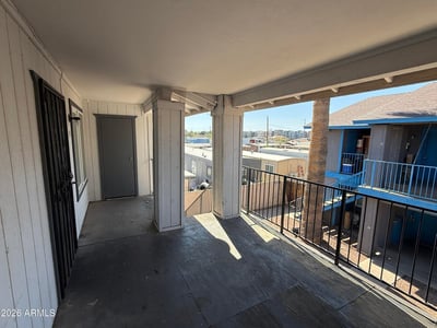 Second-level covered walkway with railings and open views overlooking the community grounds. This shaded exterior space enhances accessibility while contributing to the property's welcoming atmosphere.