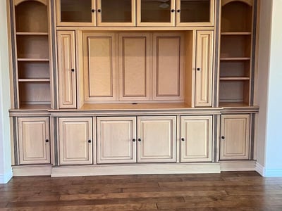 Beautiful custom entertainment wall featuring rich built-in cabinetry, open display shelves, enclosed storage, and premium craftsmanship that adds elegance and functionality to the great room.