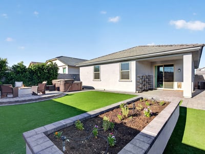 Professionally finished with synthetic grass, raised planter beds, paver patios, and covered outdoor living, this backyard provides the perfect blend of beauty, comfort, and low-maintenance landscaping.