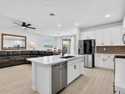 Designed for modern living, this beautiful kitchen features quartz countertops, stainless steel appliances, a large center island, abundant cabinetry, and an open layout connecting seamlessly to the great room.