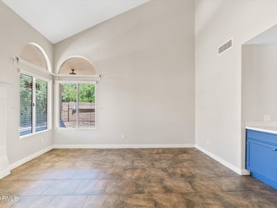 Vaulted ceilings and oversized windows create a bright, open family room with plenty of space for relaxing or entertaining. Its seamless connection to the kitchen enhances the home's functional floor plan.