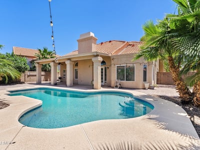 Enjoy resort-style outdoor living with a sparkling swimming pool, covered patio, mature tropical landscaping, and inviting entertaining spaces. This Chandler backyard is designed for relaxing and gathering year-round.
