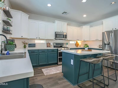 Bright, open kitchen with quartz countertops, stainless steel appliances, generous cabinet storage, and an oversized island perfect for meal prep, entertaining, and everyday living.