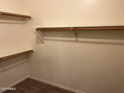 This oversized walk-in closet provides extensive hanging space and organized storage, making it easy to keep wardrobes and personal belongings neatly arranged.