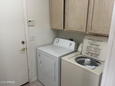 Enjoy the convenience of a dedicated laundry room complete with washer, dryer, built-in cabinetry, and practical storage to simplify daily routines.