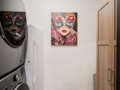Bright laundry area featuring modern appliances and artistic decor, enhancing the ambiance of this functional space.