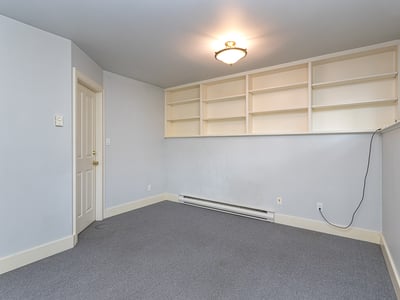Spacious room featuring built-in shelves and neutral tones, perfect for a home office or study.