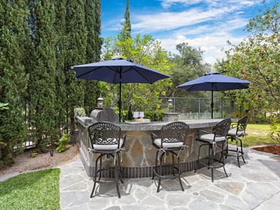 Discover a spacious outdoor bar area with ample seating and shade for relaxing gatherings.