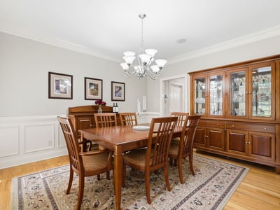 Elegant formal dining room with hardwood floors, detailed wainscoting, crown molding, and room to gather comfortably for holidays, dinner parties, and everyday celebrations.