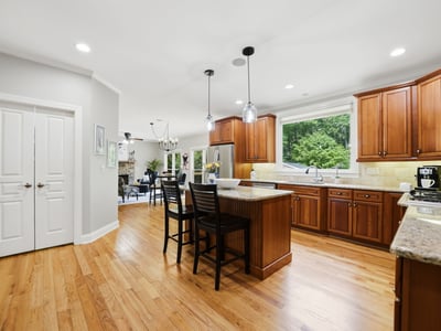 Modern kitchen with spacious island, abundant natural light, and rich wood cabinetry, perfect for entertaining.